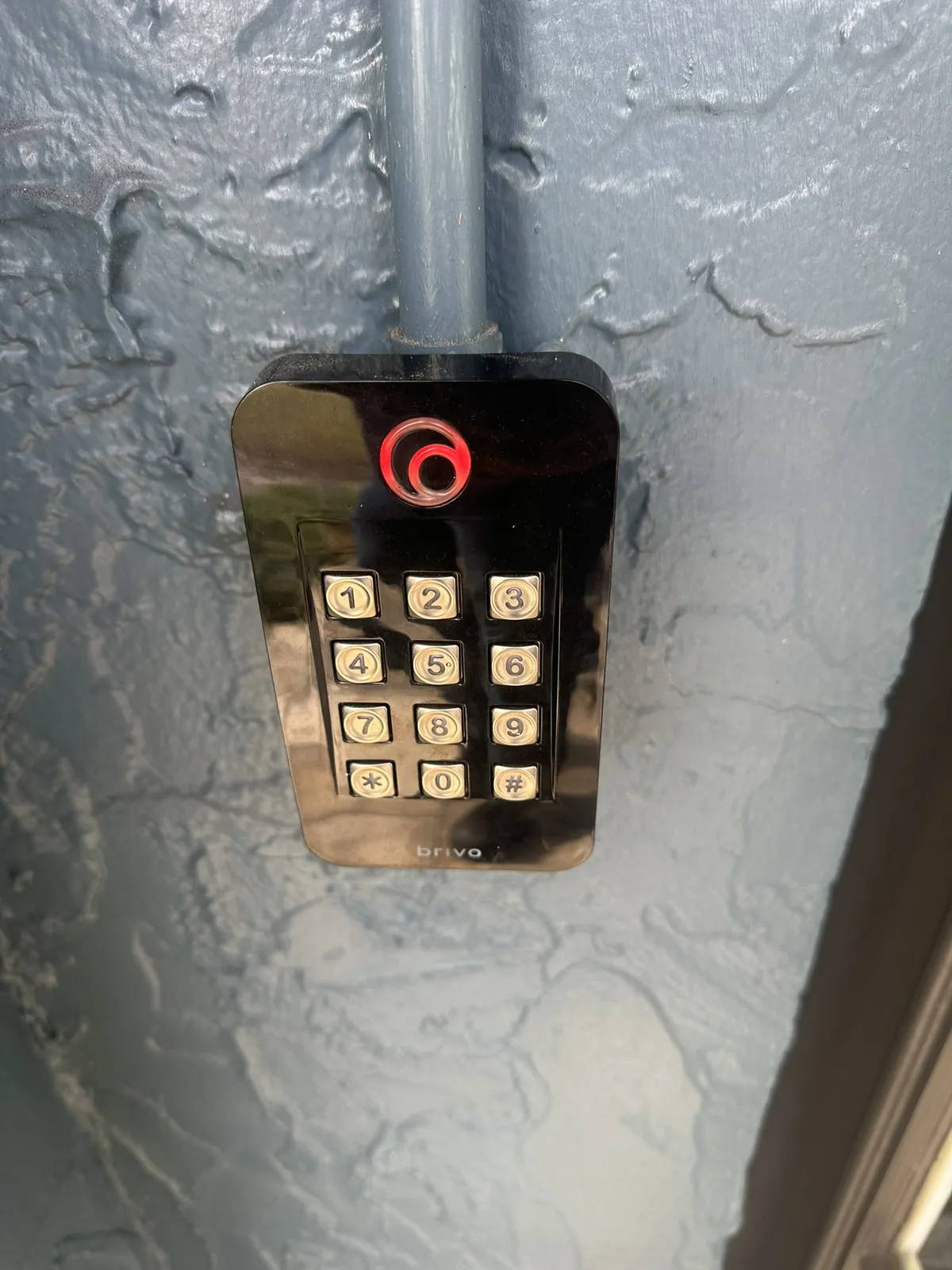 Keypad access reader mounted below conduit on an exterior wall at a Data Pro Communications project in Orlando, FL