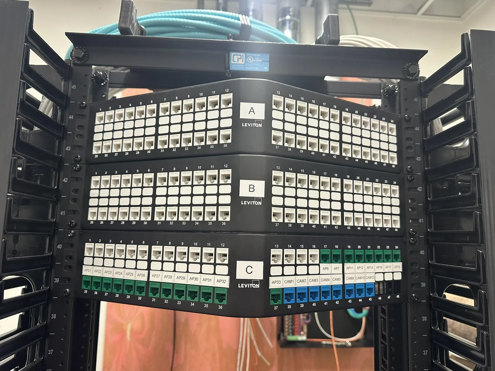 Front view of labeled patch panel rows on open network racks at a Data Pro Communications project in Orlando, FL