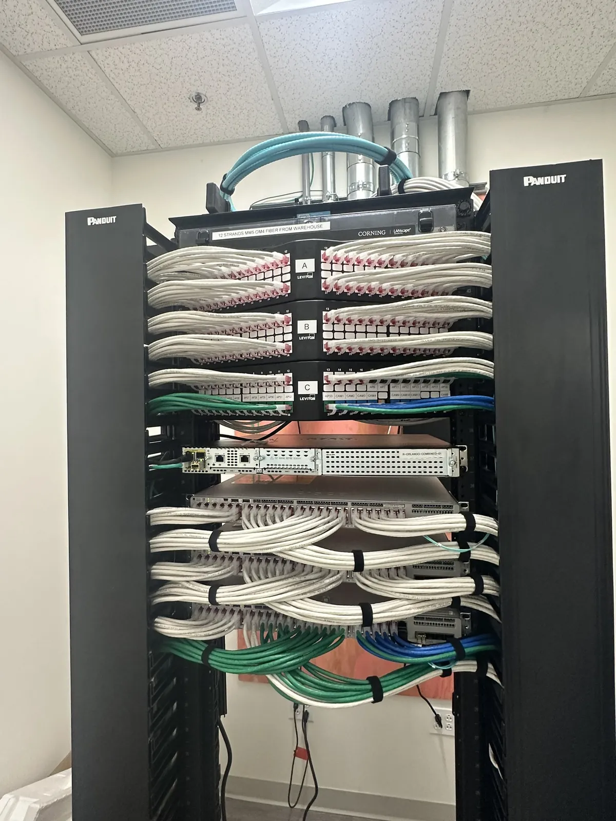 Floor-standing network rack with patch panels and dressed cabling at a Data Pro Communications project in Orlando, FL