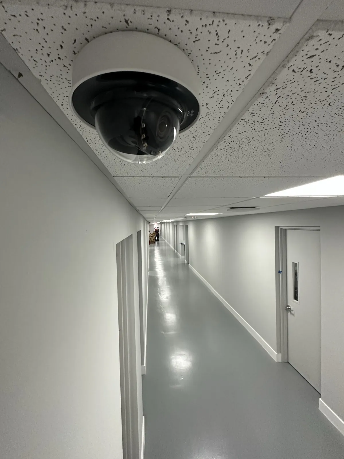 Dome camera at a corridor ceiling with hallway doors in view at a Data Pro Communications project in Orlando, FL