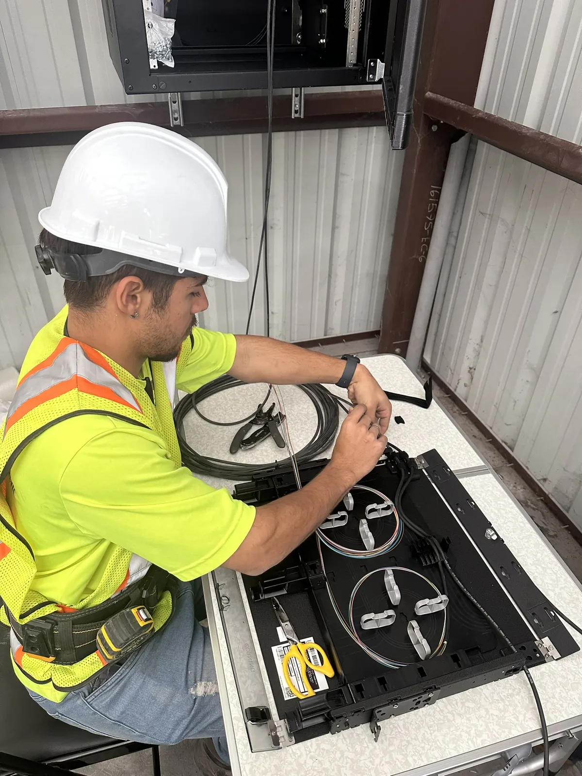 Fiber optic technician preparing a fiber tray and splice management at a Data Pro Communications project in Orlando, FL