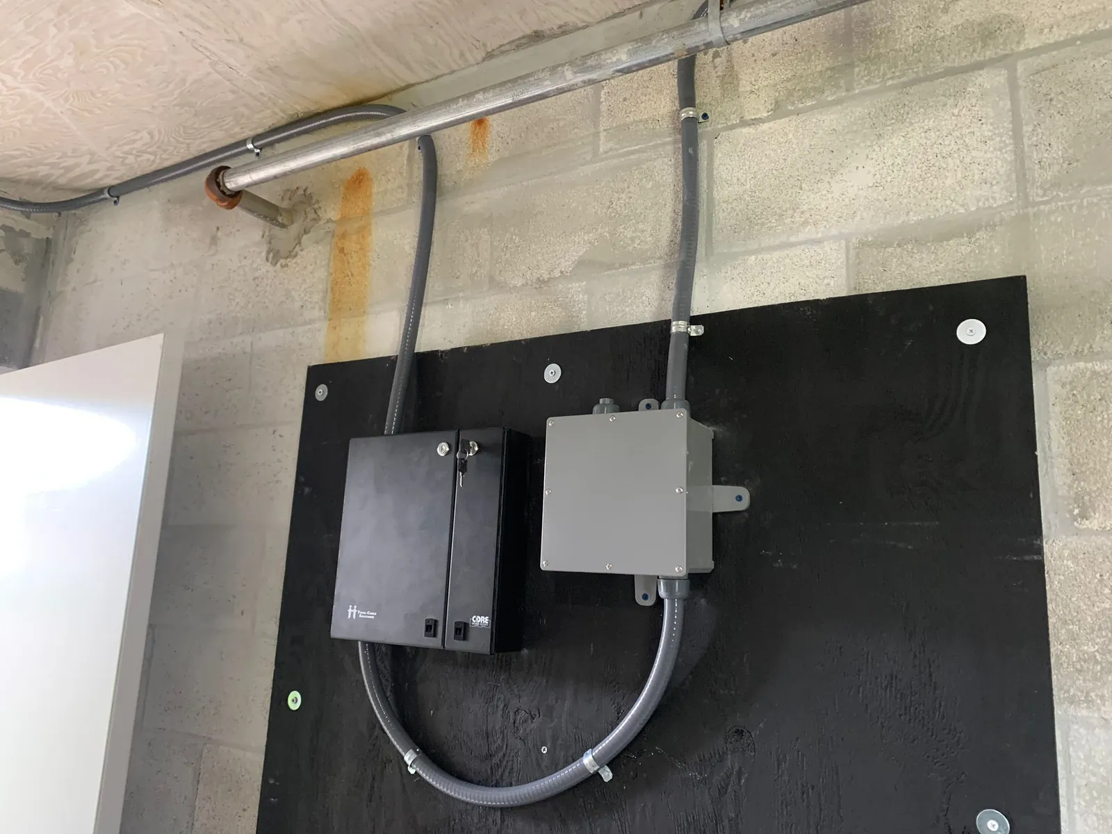 Wall-mounted telecommunications enclosures and conduits on a backboard at a Data Pro Communications project in Orlando, FL