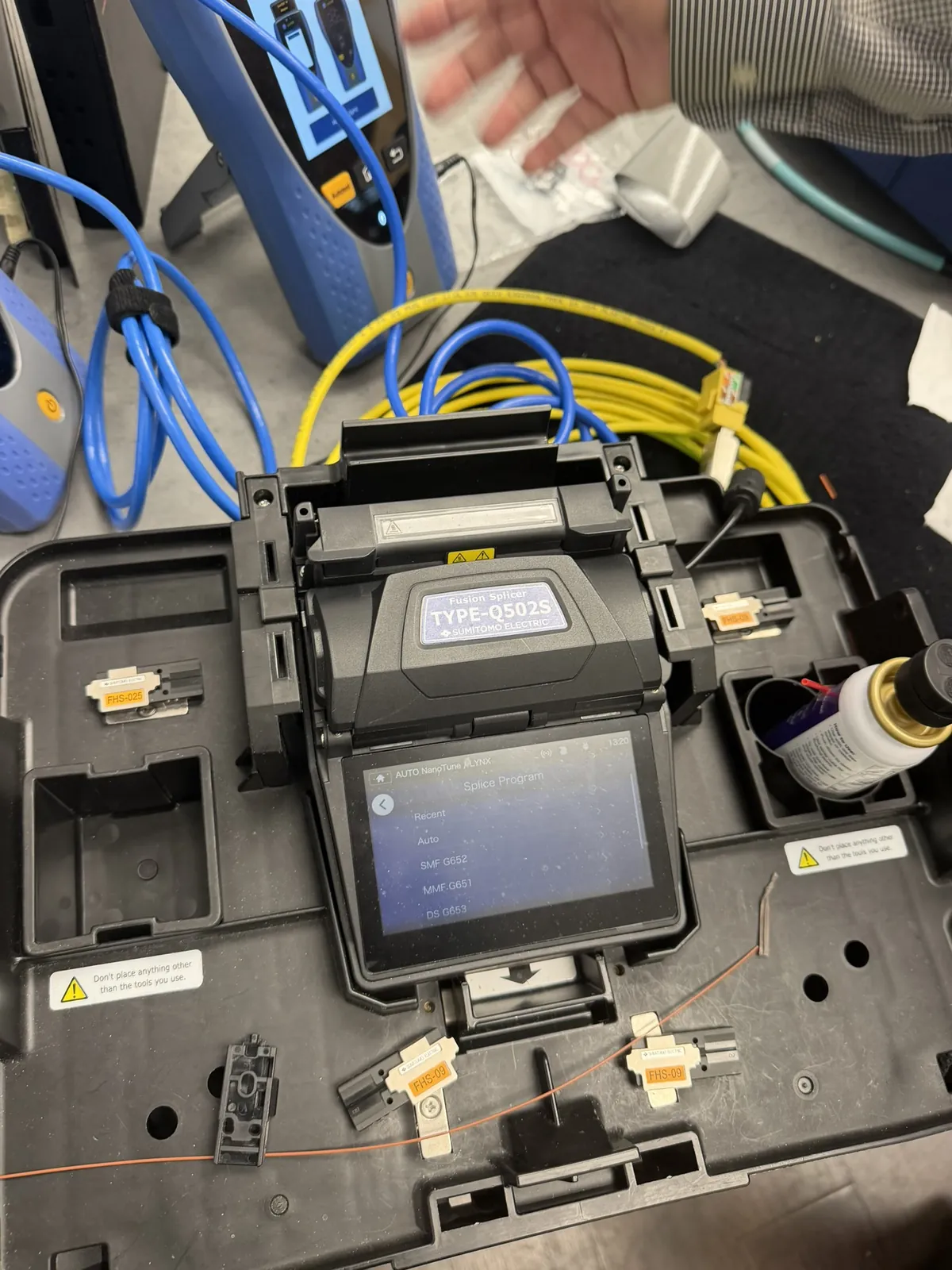 Fusion splicer joining single-mode fiber strands at a Data Pro Communications project in Orlando, FL