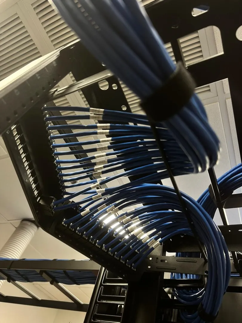 Dressed blue cable bundles entering rack patch panels at a Data Pro Communications project in Orlando, FL