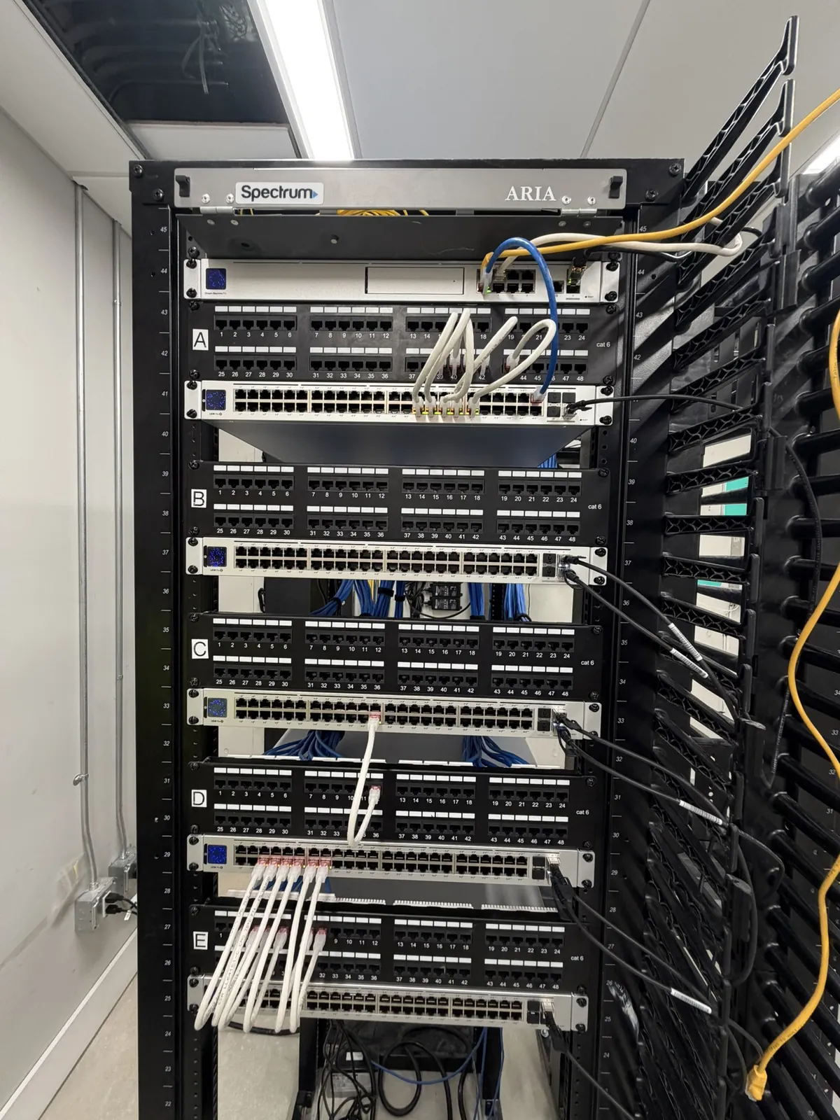 Office rack with patch panels, switches and vertical cable manager at a Data Pro Communications project in Orlando, FL