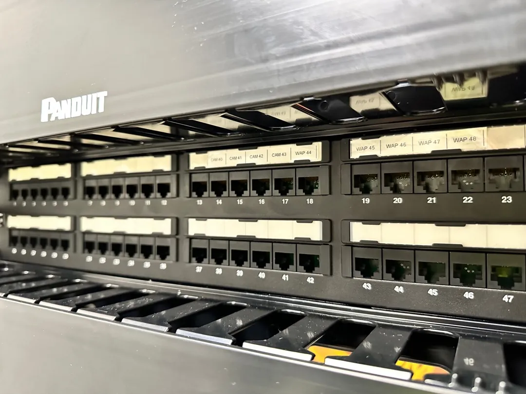 Close-up of labeled Cat6 patch panel ports in a warehouse rack at a Data Pro Communications project in Orlando, FL