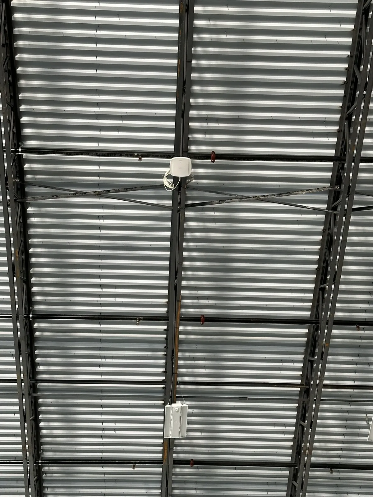 Wireless access point on high-bay warehouse roof joists at a Data Pro Communications project in Orlando, FL