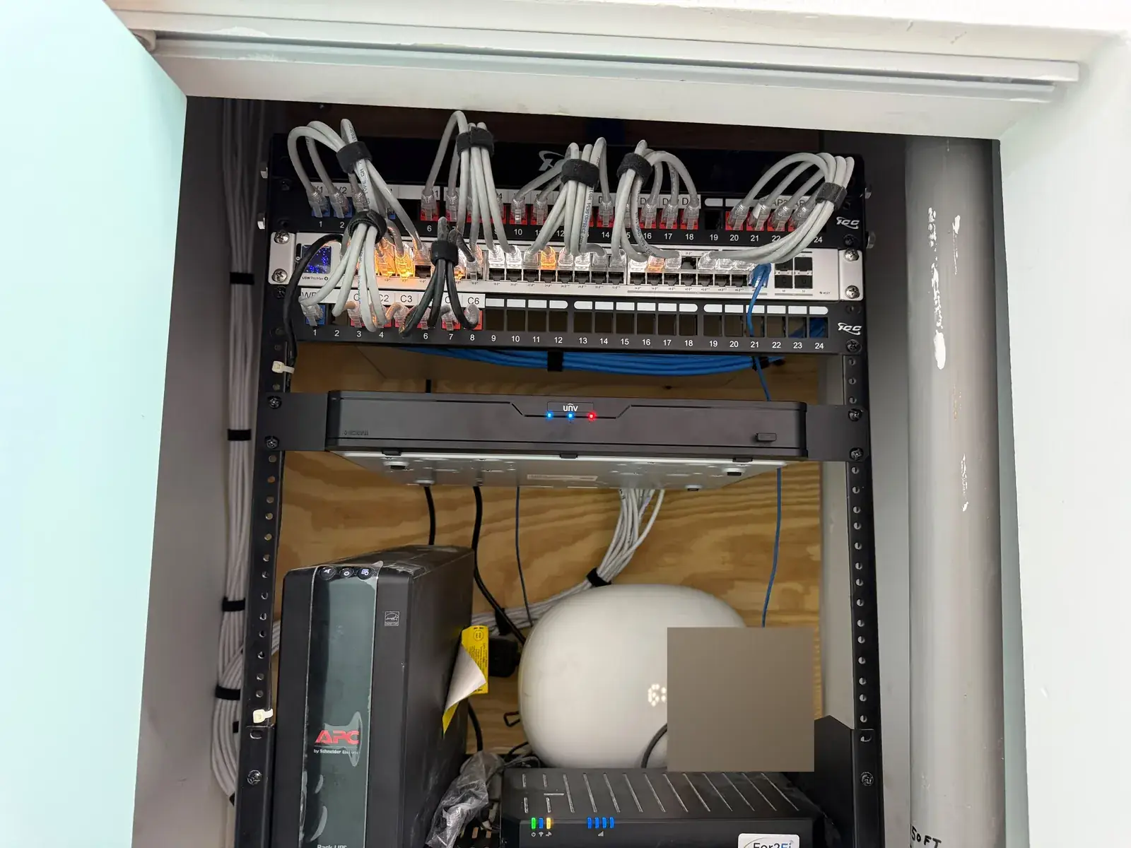Wall rack w/ NVR, patch panel (open) at a Data Pro Communications project in Orlando (Lake Nona), Plantation & Jacksonville, FL